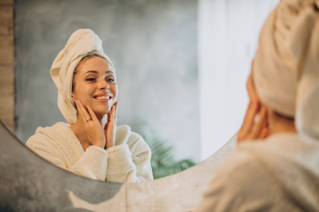 Na imagem, mulher realizando rotinas de skincare